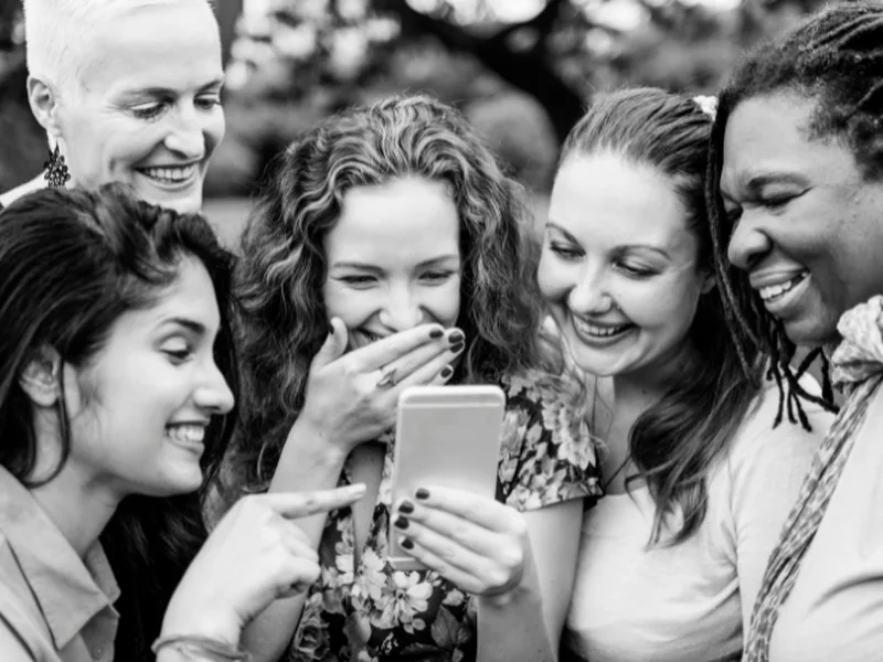 Friends laughing together while reliving the night in the shared GuestView gallery